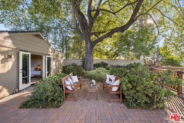 a view of a patio with chair and tables back yard of the house