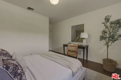 a bedroom with a bed and a potted plant