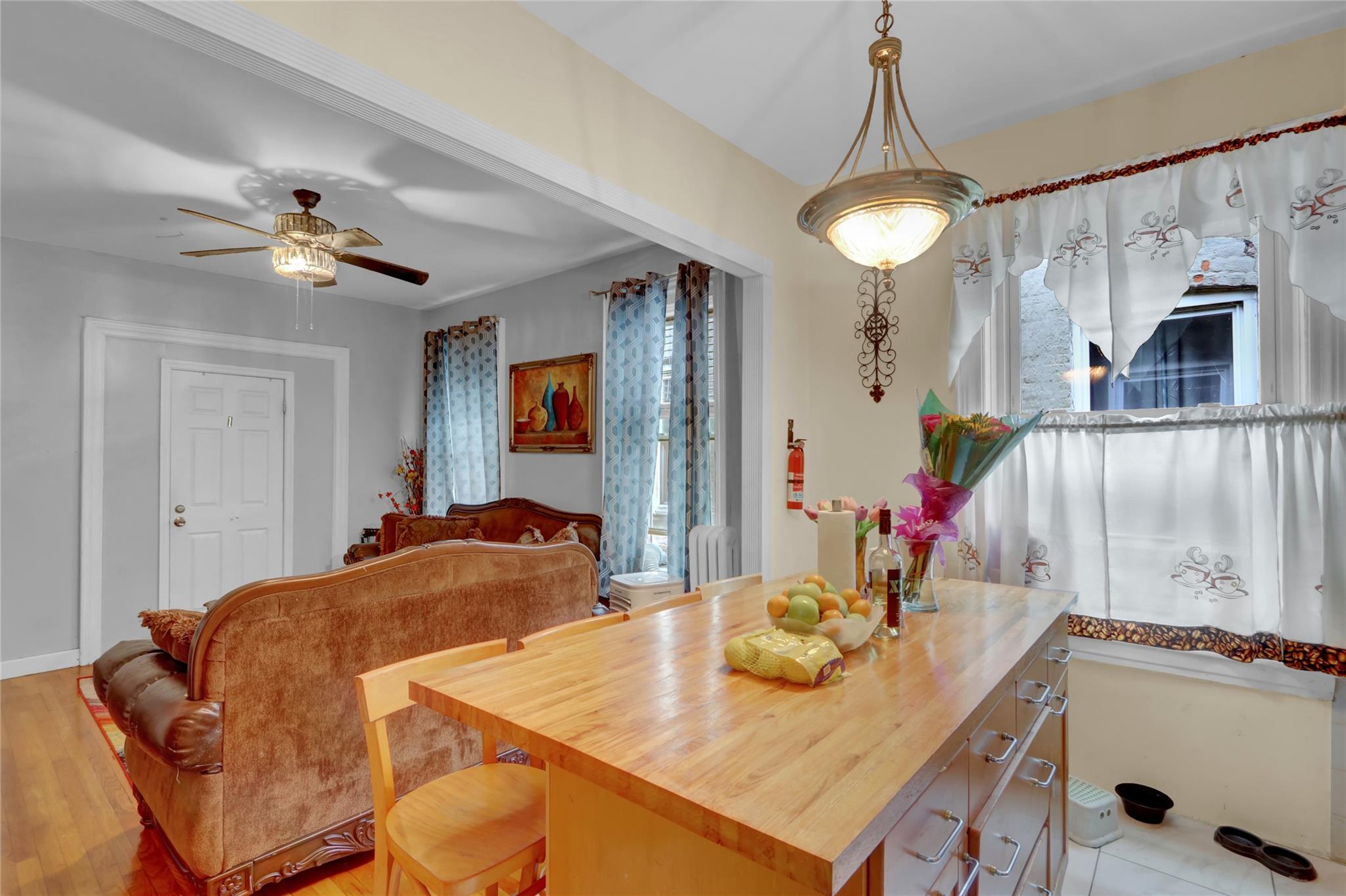 31 Tapscott Street Brooklyn, NY 11212 - Photo 5 of 10 Dining space featuring a ceiling fan, light wood-style floors, and radiator