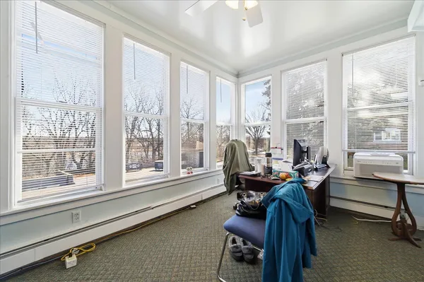 a view of a workspace with furniture and a window