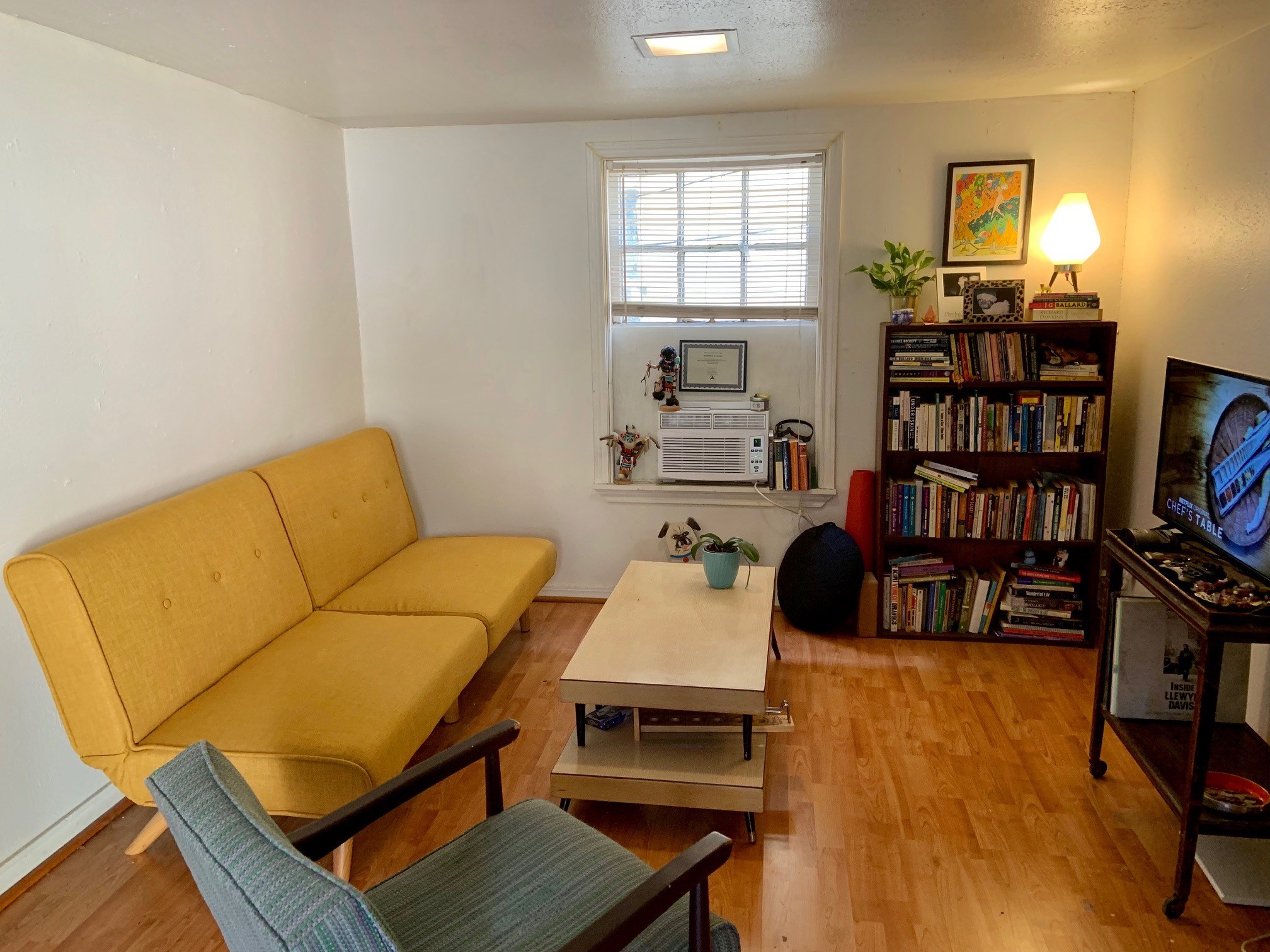 a living room with furniture a flat screen tv and a bookshelf