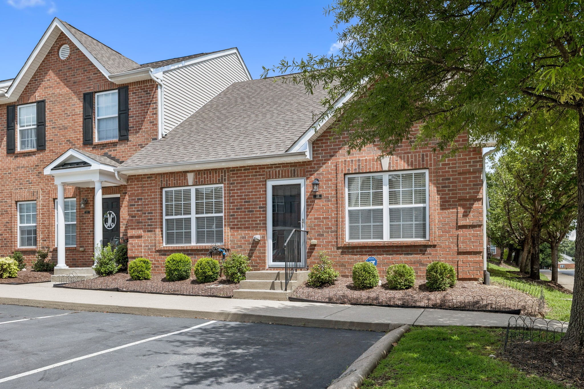 1101 Downs Boulevard, Unit 316 Franklin, TN 37064 - Photo 2 of 26 front view of a brick house with a yard and large trees