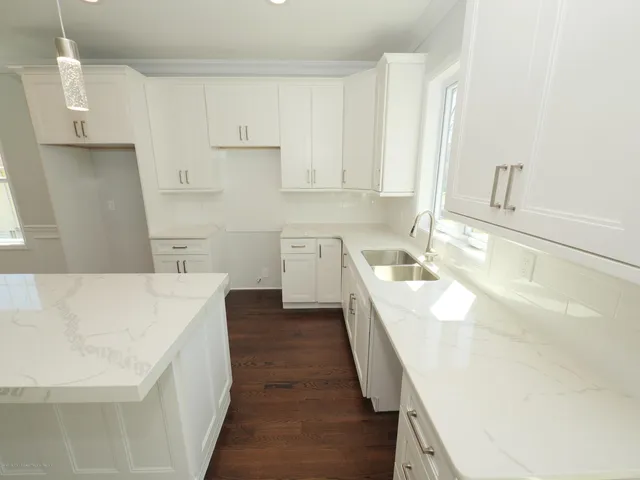 a kitchen with kitchen island sink stove and cabinets