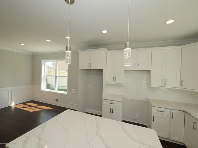 a kitchen with kitchen island white cabinets appliances and a window