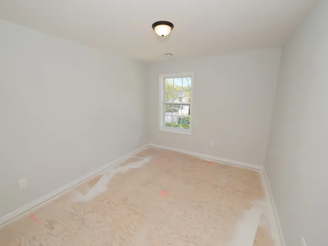 an empty room with windows and closet