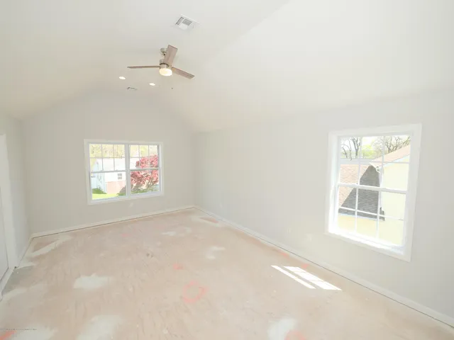 an empty room with windows and fan