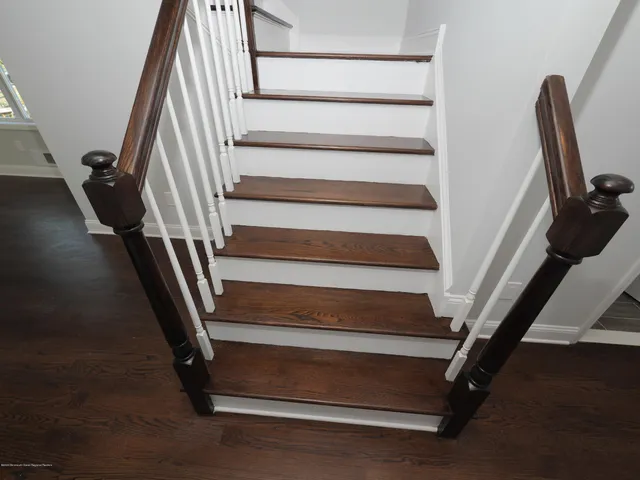 a view of staircase with white walls and a floor
