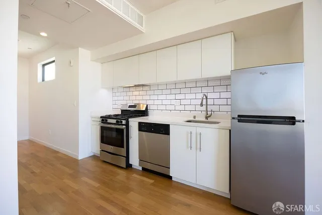 a kitchen with granite countertop wooden floors and stainless steel appliances