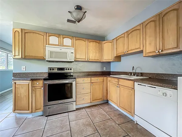 a kitchen with granite countertop a stove sink and cabinets