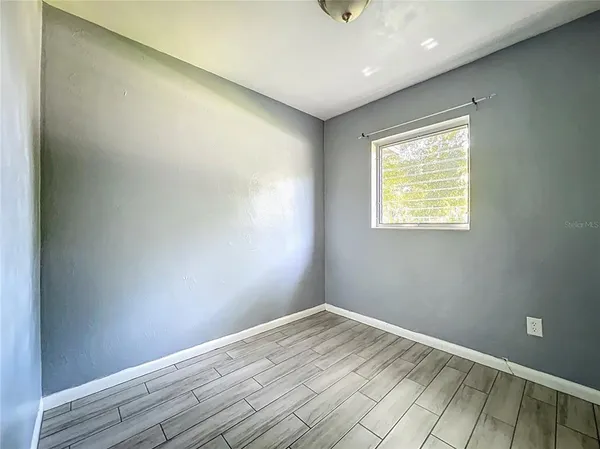an empty room with wooden floor and a window
