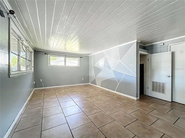 a view of an empty room with stairs and a window