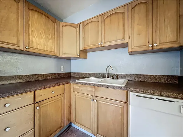 a kitchen with stainless steel appliances granite countertop white cabinets stove a sink and dishwasher