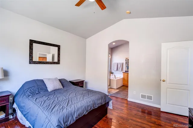 a spacious bedroom with a bed and a lamp