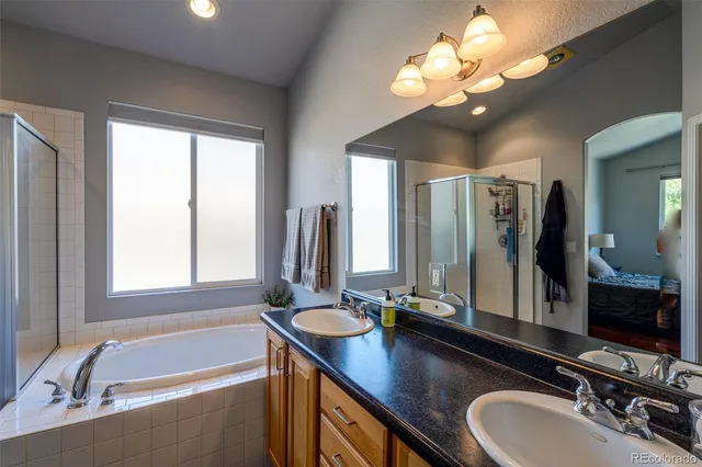 a bathroom with a tub a double vanity sink and a mirror
