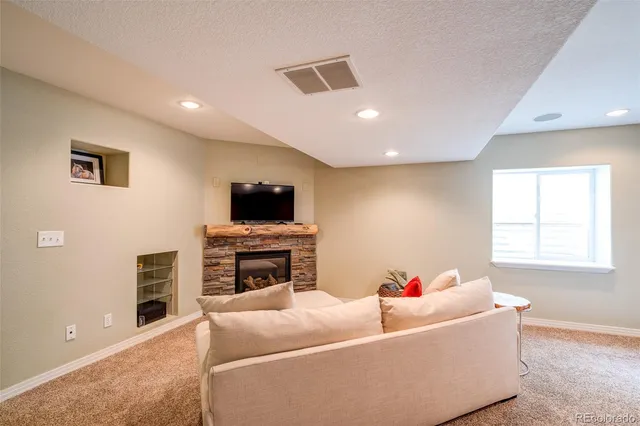a living room with furniture a flat screen tv and a fireplace