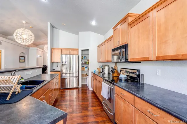 a kitchen with stainless steel appliances granite countertop a stove a sink and a refrigerator
