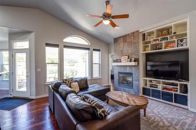 a living room with furniture a flat screen tv and a fireplace