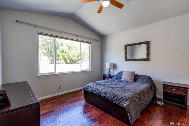 a bedroom with a bed wooden floor and window