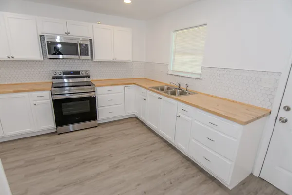 a kitchen with stainless steel appliances granite countertop a stove a sink and a microwave