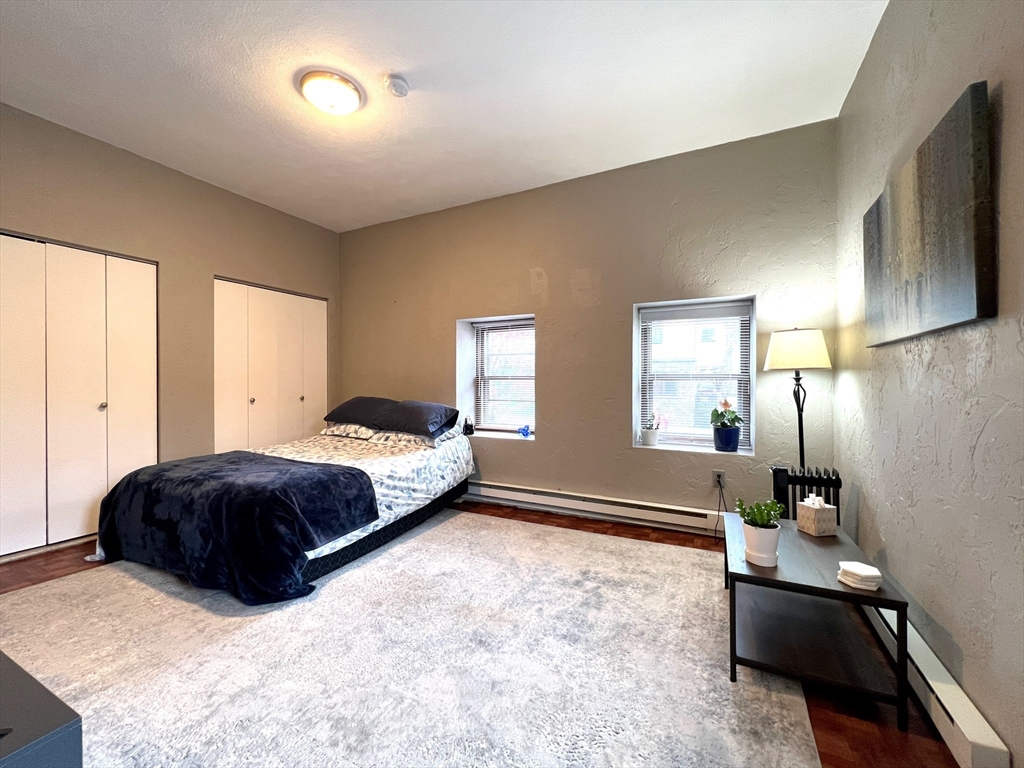 a living room with a bed furniture and a flat tv screen