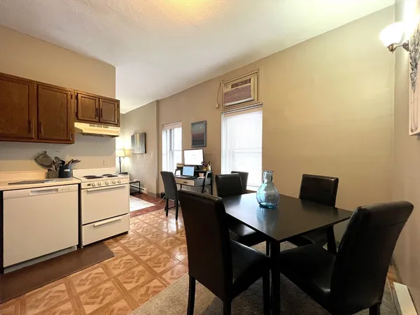 a kitchen with a table chairs and a refrigerator