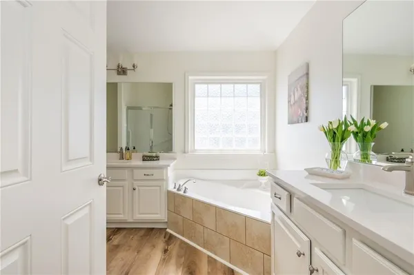 a bathroom with a granite countertop bathtub a sink and a window