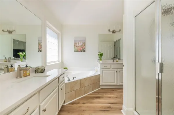 a bathroom with a double vanity sink a mirror and a bathtub