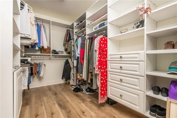 a view of walk in closet with clothes and shoes