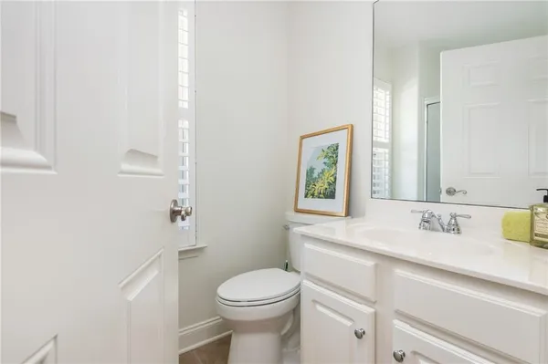 a bathroom with a sink vanity mirror and toilet