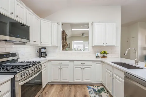 a kitchen with cabinets appliances and a sink