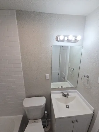 a bathroom with a sink toilet and mirror