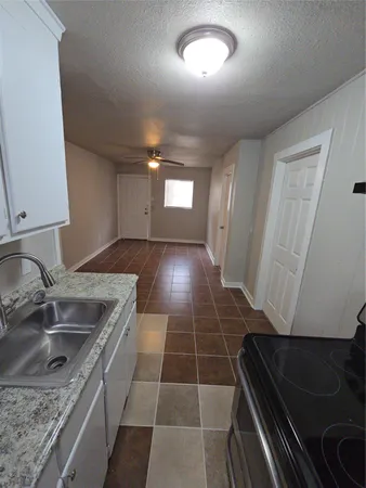 a kitchen with a sink a stove and cabinets