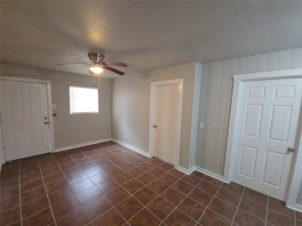 an empty room with windows and fan