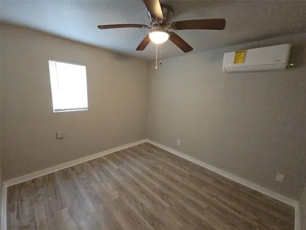 an empty room with a window and a fan