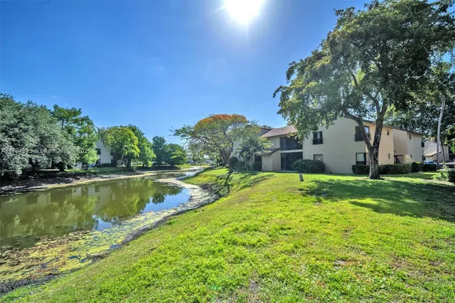 a view of a house with pool and a yard