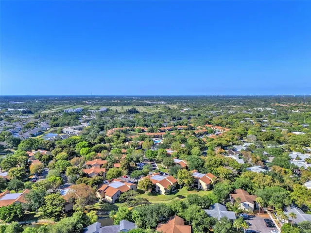 an aerial view of residential houses with outdoor space and trees