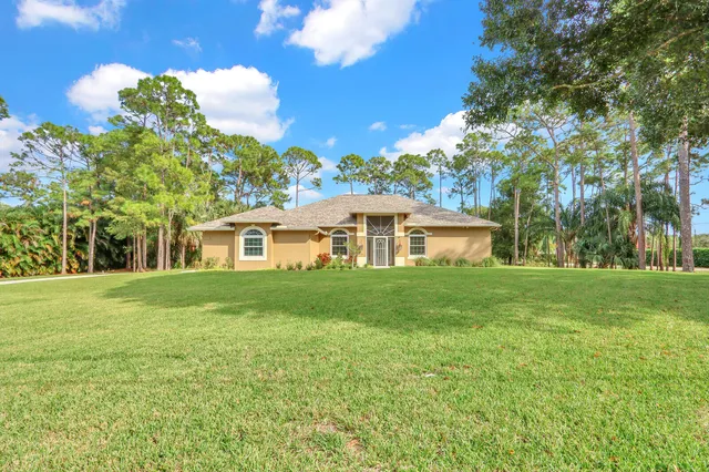 a view of a livingroom with wooden floor and a kitchen