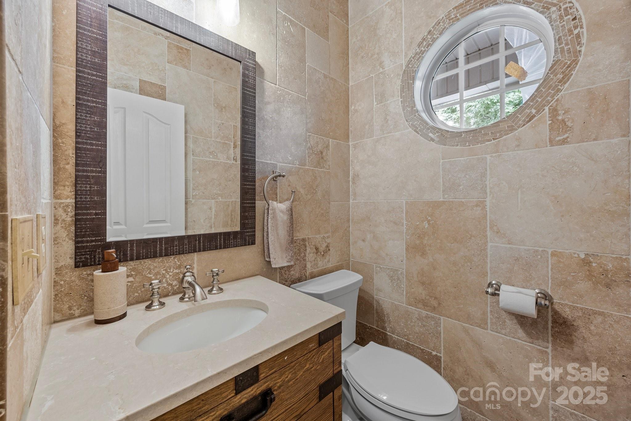 10919 Valley Spring Drive Charlotte, NC 28277 - Photo 25 of 47 a bathroom with a granite countertop toilet a sink and a mirror
