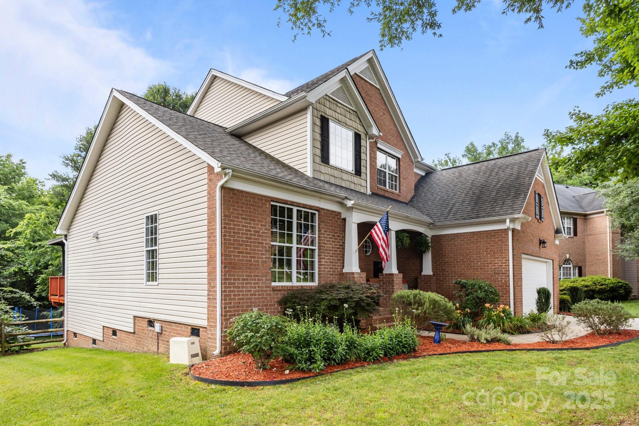 10919 Valley Spring Drive Charlotte, NC 28277 - Photo 3 of 47 a front view of a house with a yard and potted plants
