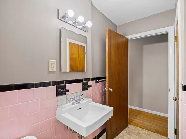 a bathroom with a sink a light fixture and a mirror