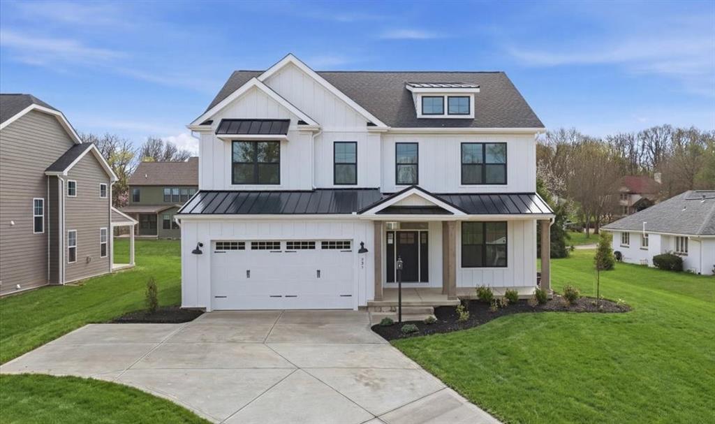 Modern Farmhouse Elevation with covered Front Porch, Cedar Wrapped Columns, Board and Batten Siding, Metal Roof Accents & Black Exterior Windows