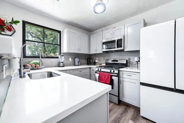 a kitchen with stainless steel appliances a refrigerator sink and microwave