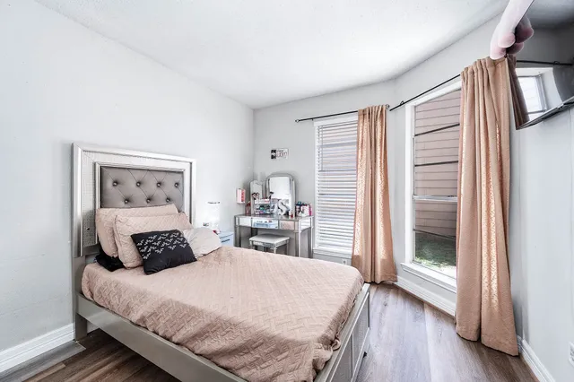 a bedroom with a large bed and wooden floor