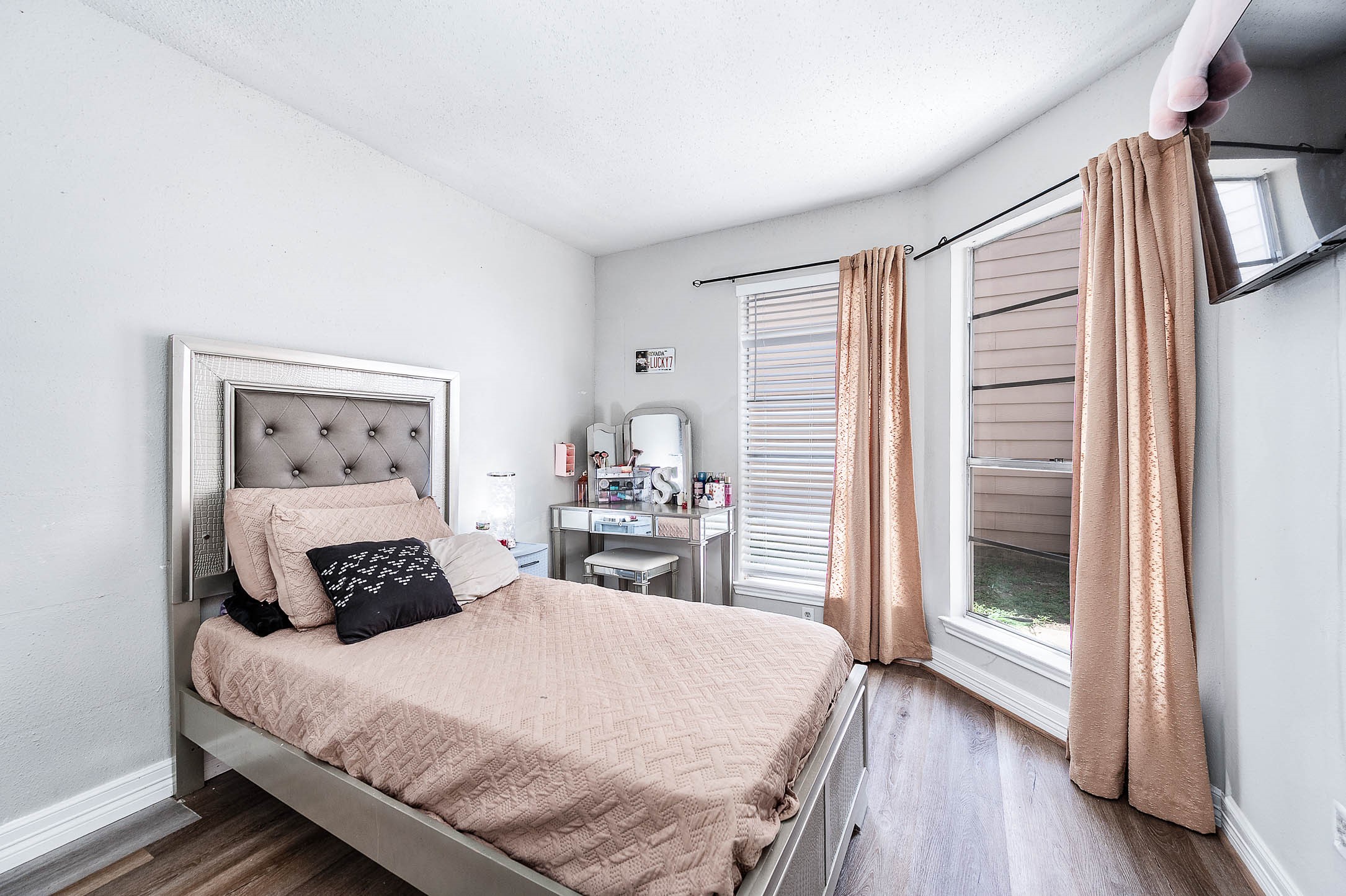 18446 North Willow Bluff Road Katy, TX 77449 - Photo 16 of 31 a bedroom with a large bed and wooden floor