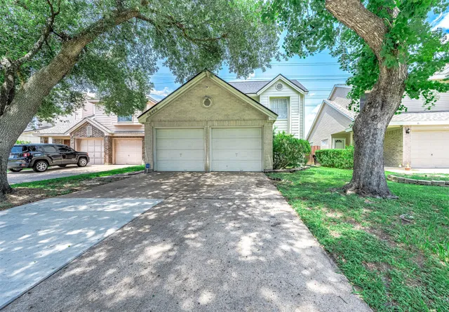 a front view of a house with yard and tree