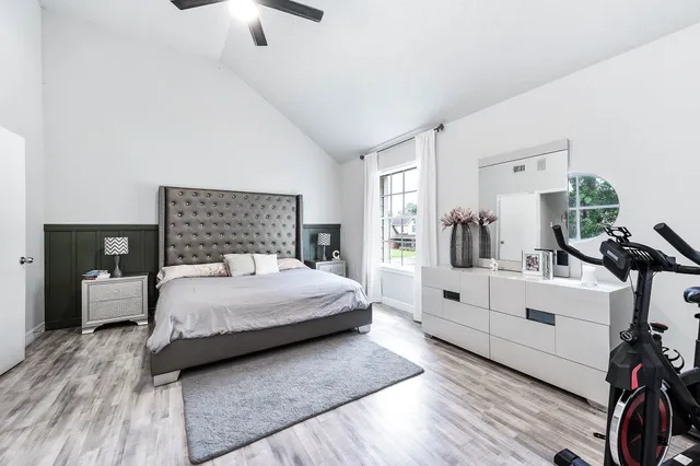 a bedroom with a large white bed and white walls