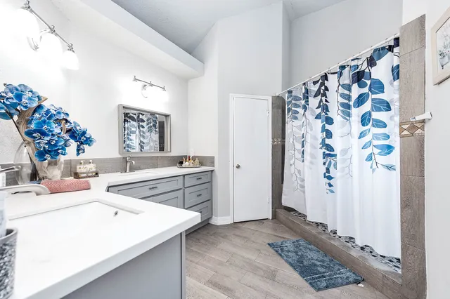 a spacious bathroom with a sink mirror and shower