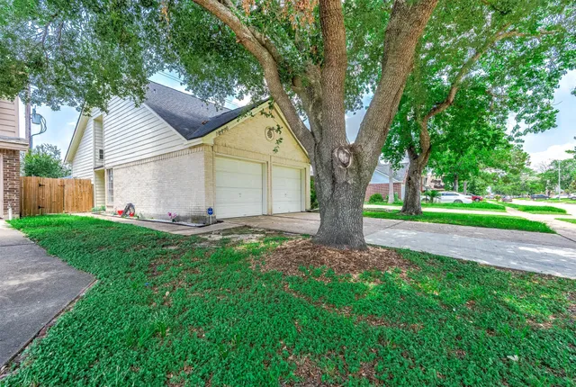 a view of a house with a tree in the yard
