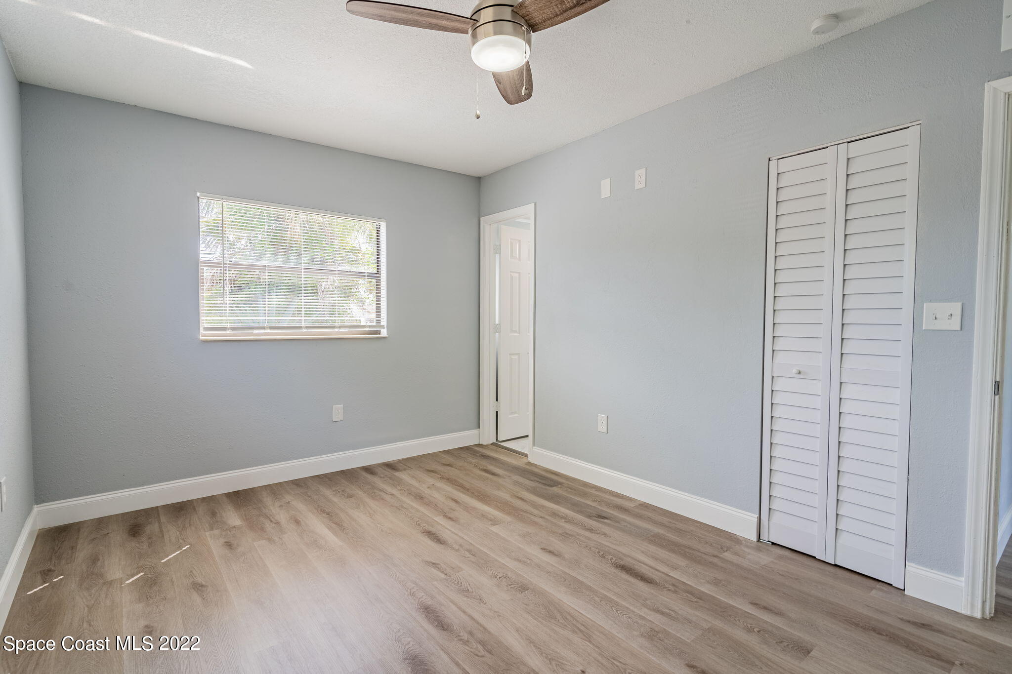 302 Prospect Avenue Cocoa, FL 32922 - Photo 12 of 28 an empty room with wooden floor cabinet and windows