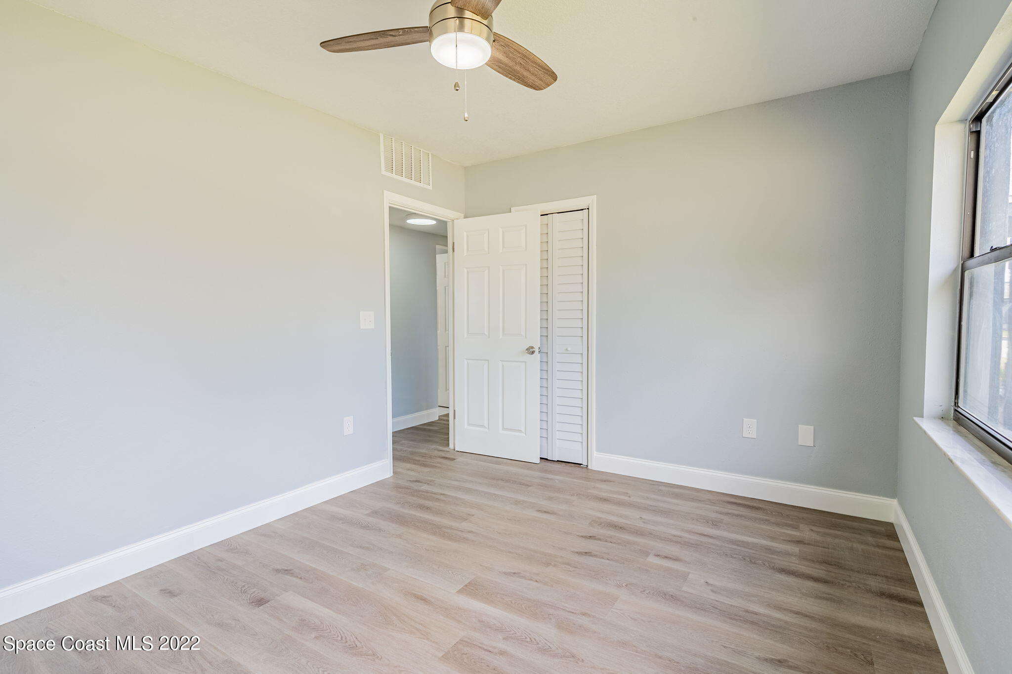 302 Prospect Avenue Cocoa, FL 32922 - Photo 19 of 28 an empty room with wooden floor and windows